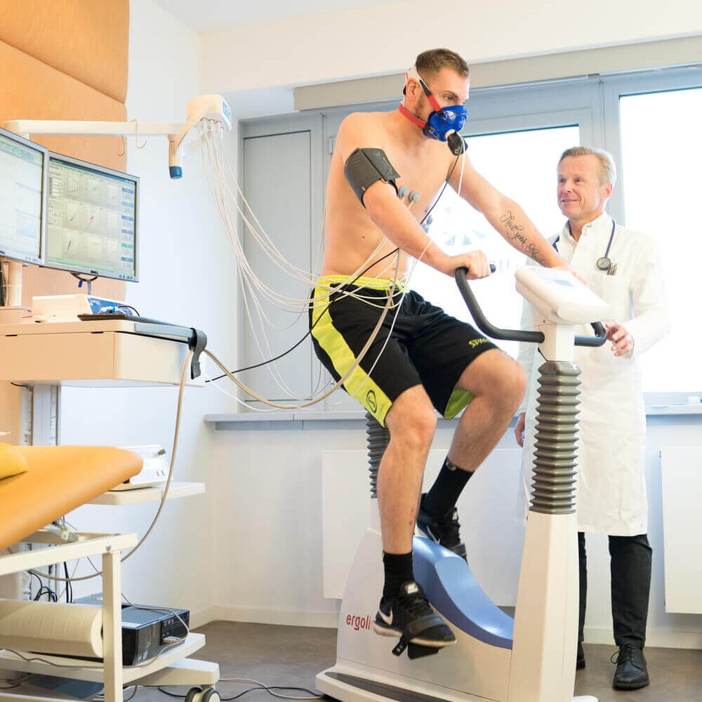 Facharzt für Kardiologie: Dr. med. Heidland begleitet den Patienten während dem Belastungs-EKG auf dem Fahrrad-Ergometer